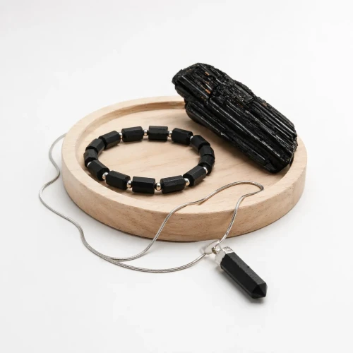 Zestaw ochronny z turmalinem czarnym – bransoletka i naszyjnik z grotem na eleganckim zdjęciu produktowym.