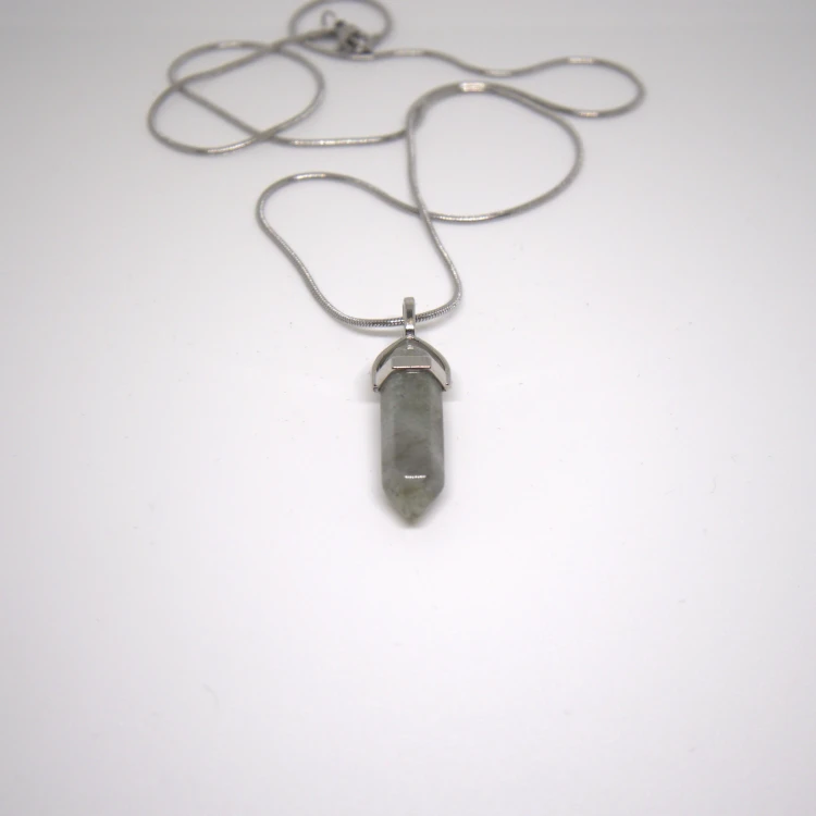 Zbliżenie naszyjnika z labradorytu na srebrnym łańcuszku, subtelny kamienny grot na jasnym tle.