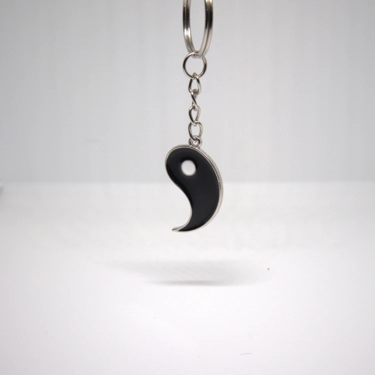 Czarny breloczek Yin Yang zawieszony na kółku, stal nierdzewna, prosty symbol harmonii i połączenia.